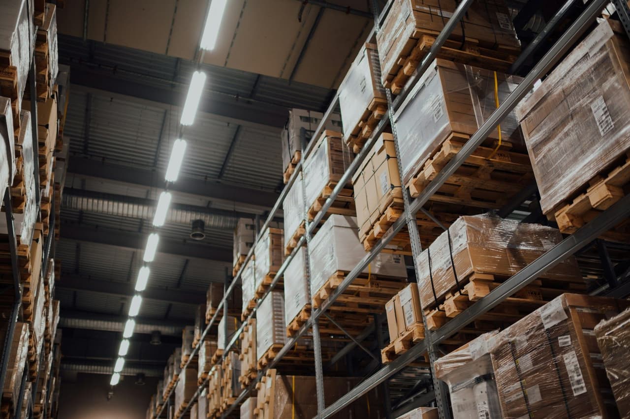 Magazijnstellingen met gestapelde pallets en dozen tot aan het plafond